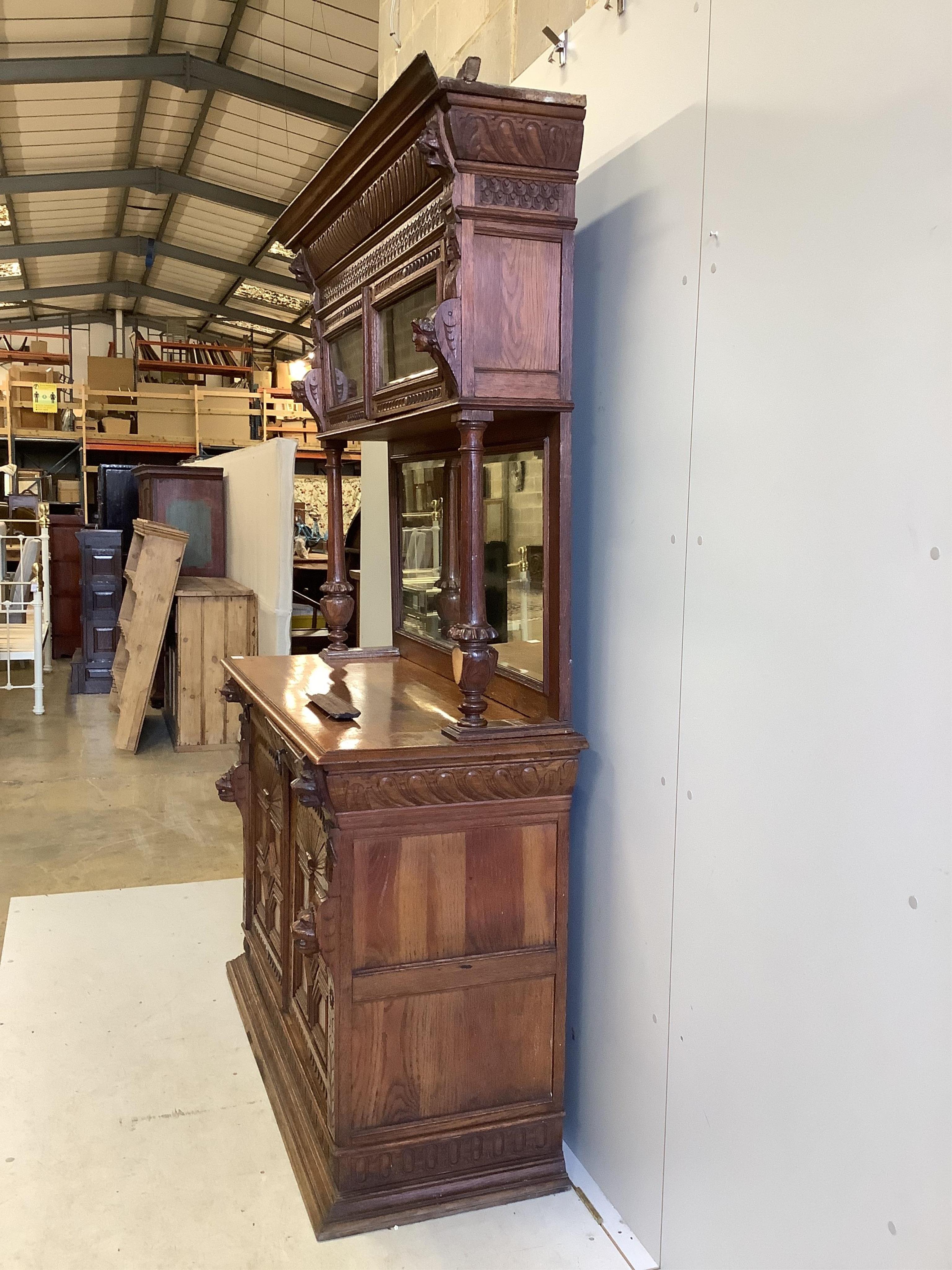 A 19th century Flemish carved oak buffet, width 139cm, depth 54cm, height 214cm. Condition - fair, two pieces of moulding detached but present